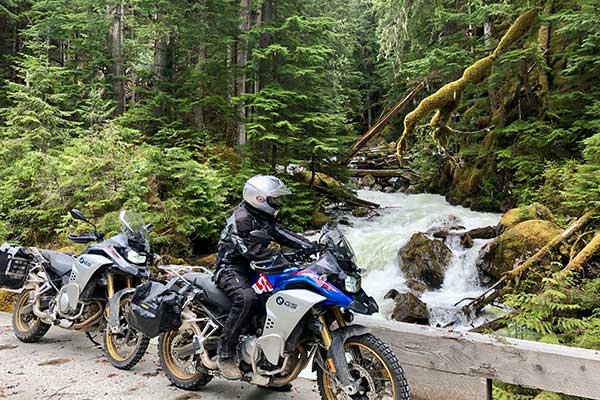 waterfall in the background by a parked biker